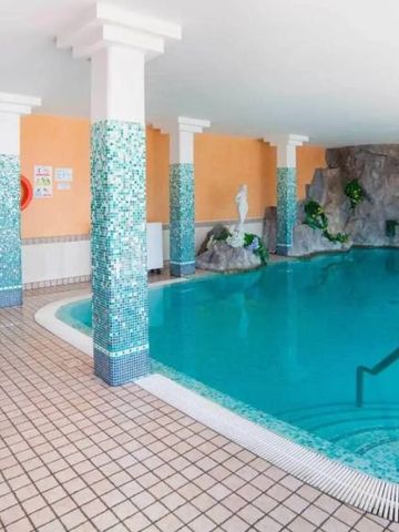 Innenpool mit Säulen und Wasserkaskade an den Wänden