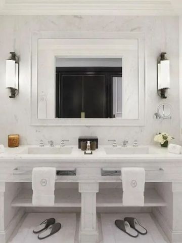 Luxuriöses Badezimmer mit zwei Waschbecken und stilvollen Wandlampen.