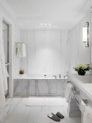 Modernes Badezimmer mit Badewanne und weißen Bademänteln.