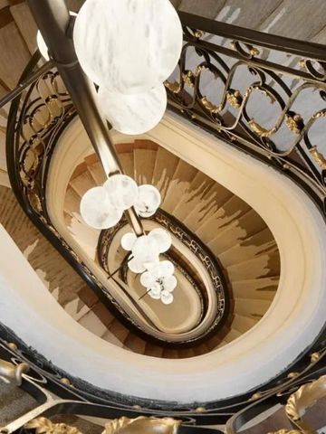 Majestätische Wendeltreppe mit kunstvollen Geländern und leuchtenden Lampen