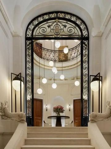 Prächtiger Eingang mit verzierter Metalltür und edlen Statuen