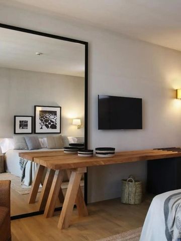 Helles und modernes Hotelzimmer mit großem Spiegel und Holzschreibtisch.