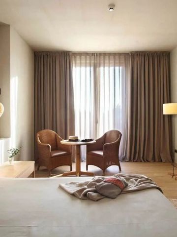 Einladendes Doppelzimmer mit Sitzbereich und natürlichem Licht durch große Fenster.