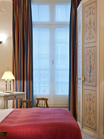 Helles Hotelzimmer mit dekorativen Wandmalereien und klassischen Möbeln.