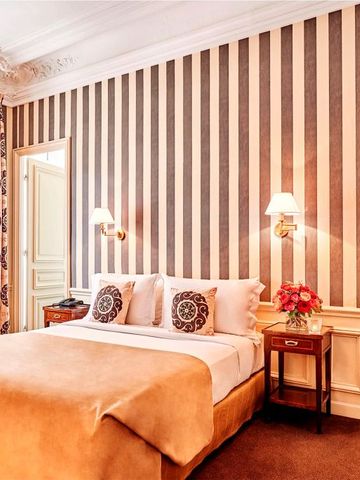 Stilvolles Hotelzimmer mit Streifenmustertapete und gemütlicher Einrichtung.