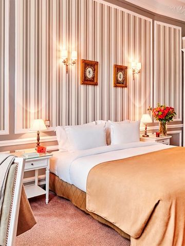 Geräumiges Schlafzimmer mit eleganter Streifentapete und klassischen Möbeln.