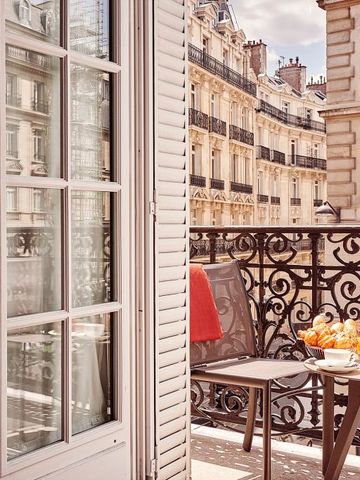 Balkon mit Stadtblick und Tisch voller frischem Obst und Getränken.