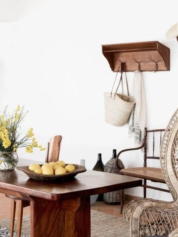 Helles Interieur mit Holzmöbeln und Rattanstuhl im Hotelzimmer.