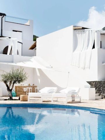 Weißer Innenhof mit Liegestühlen und sonnigem Pool