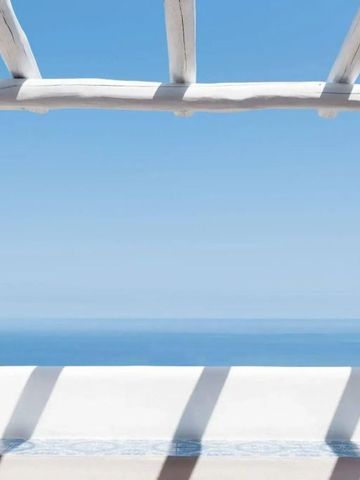 Blick auf das Meer durch eine weiße Pergola