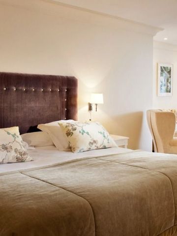 Luxuriöse Suite im klassischen Design mit Kingsize-Bett und gemütlichem Sitzbereich