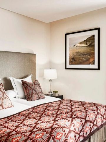 Elegantes Hotelzimmer mit stilvollem Kopfteil und kunstvollem Bild an der Wand