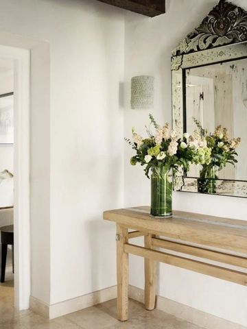 Einladender Flurbereich mit dekorativem Spiegel und frischen Blumen