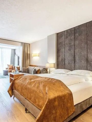 Geräumiges Hotelzimmer mit großem Bett und gemütlicher Sitzecke