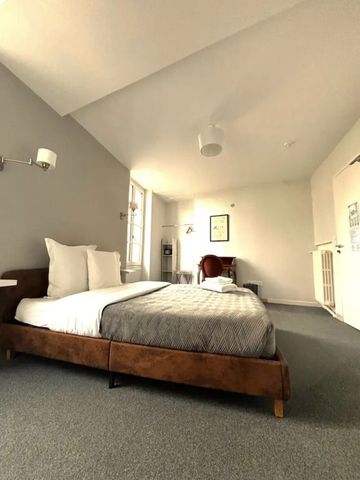 Modernes Zimmer mit Doppelbett und minimalistischer Einrichtung.