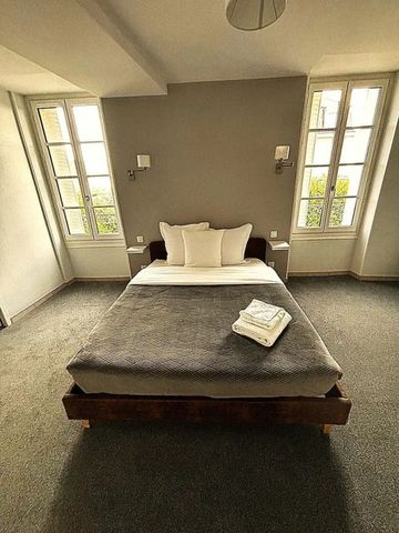 Gemütliches Hotelzimmer mit Doppelbett und großen Fenstern