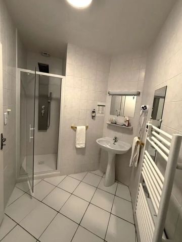 Helles Badezimmer mit Dusche und Handtuchheizung