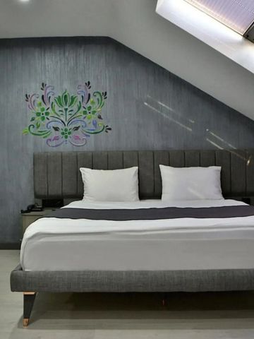 Modernes Dachgeschosszimmer mit elegantem Design und Kunstwerk an der Wand