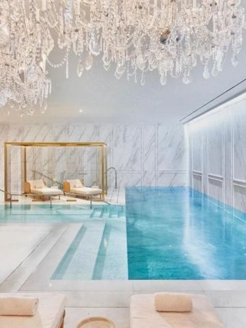 Luxuriöser Indoor-Pool mit Wasserfall und geschmackvollen Chaiselongues