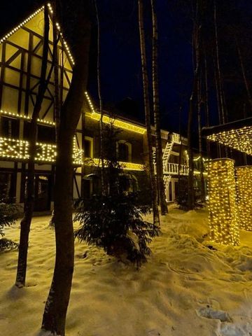 Beleuchtetes Hotelgebäude im Winter mit Lichterketten und schneebedecktem Boden.