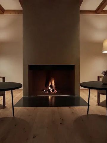 Einladende Lounge mit Kamin und schlichter moderner Einrichtung
