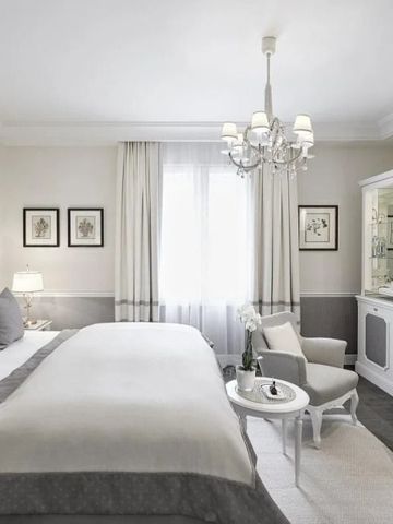 Helles Hotelzimmer mit klassischem Interieur und hochwertiger Bettwäsche