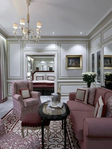 Elegantes Wohnzimmer in hellen Farben mit kunstvollen Möbeln und Kronleuchter