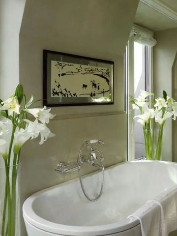 Luxuriöses Badezimmer mit eleganter Badewanne und weißen Lilien
