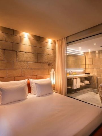 Modernes Hotelzimmer mit Glaswand und stilvollem Badezimmer