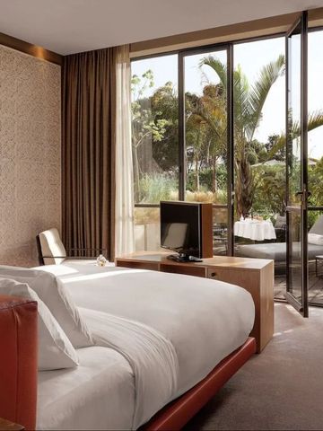 Luxuriöses Hotelzimmer mit Terrasse und Blick auf tropische Pflanzen