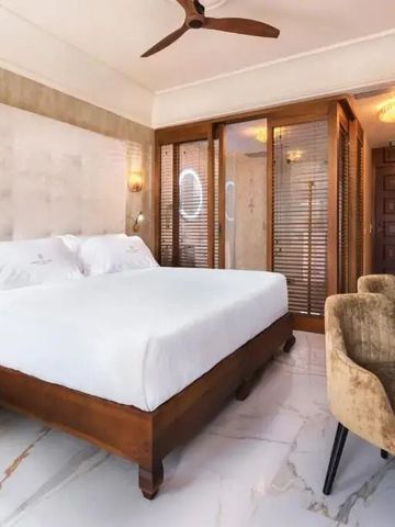 Helles Hotelzimmer mit großem Bett und eleganter Einrichtung.