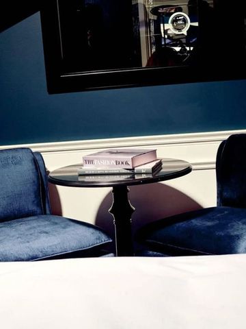 Eleganter Sitzbereich mit blauen Samtstühlen und kleinem Tisch