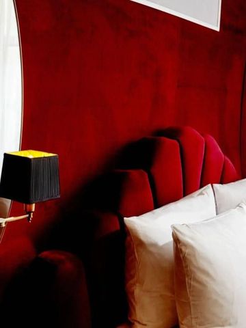 Luxuriöses rotes Bett mit weißen Kissen und goldenen Akzenten