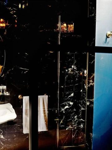 Luxuriöses Badezimmer mit Marmorelementen und goldenen Details