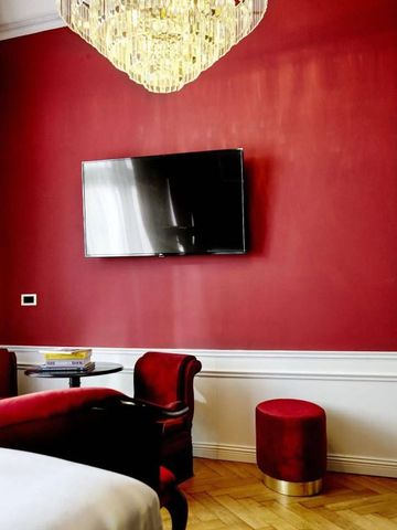 Roter eleganter Raum mit stilvollen Möbeln und großem Flachbildfernseher.