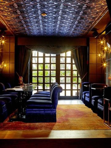 Opulent eingerichteter Raum mit blauen Sitzmöbeln und dekorativer Beleuchtung.