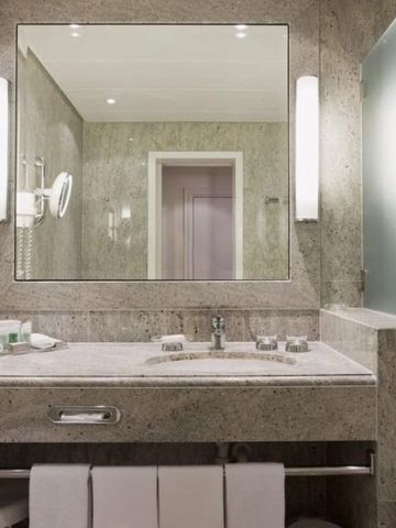 Elegantes Badezimmer mit modernen Leuchten und großem Spiegel