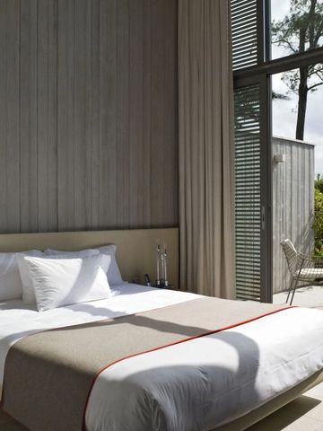 Hotelzimmer mit Fenster und Blick auf Terrasse mit Garten