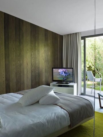 Zimmer mit Holzverkleidung und großem Fenster