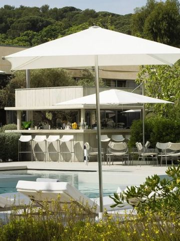 Außenbereich mit Pool und eleganter Bar unter Sonnenschirmen