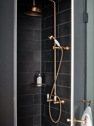 Moderne Dusche mit exquisiten Armaturen in dunklem Fliesendesign