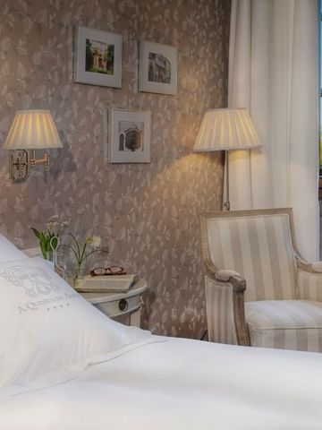 Luxuriöses Gästezimmer mit gestreiftem Sessel und Tageslicht