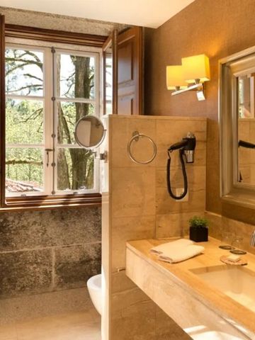 Luxuriöses Badezimmer mit Naturlicht und Holzfenster.