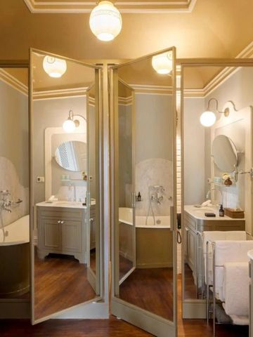 Geräumiges Badezimmer mit eleganten Spiegeln und freistehender Badewanne