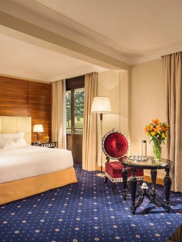 Geräumiges Hotelzimmer mit klassischer Möblierung und Gartenblick