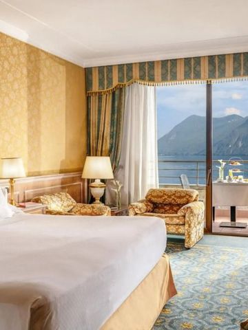 Luxuriöses Hotelzimmer mit Blick auf einen See und Berge.