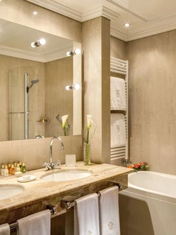 Geräumiges Badezimmer mit Marmorwaschtisch und Badewanne.