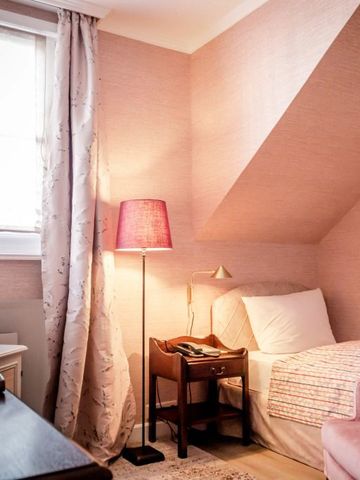 Gemütliches Einzelzimmer mit Dachschräge und rosafarbenem Dekor