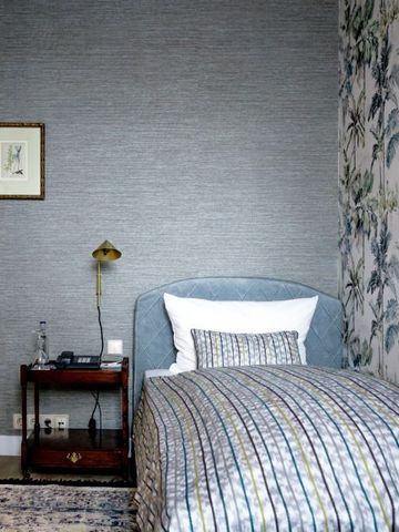 Elegantes Einzelzimmer mit floralem Design und stilvoller Tapete