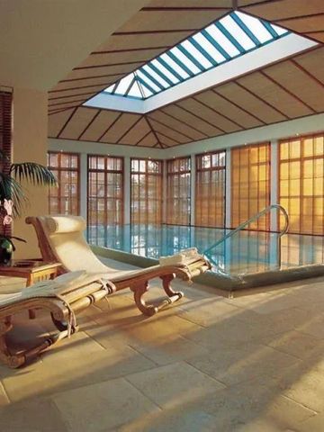 Luxuriöser Innenpoolbereich mit Liegestühlen und natürlichem Licht